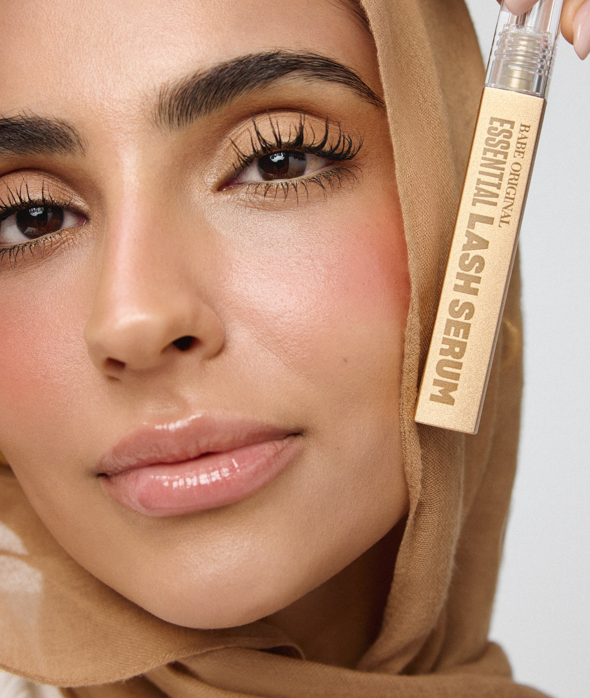 Model holding Essential Lash Serum